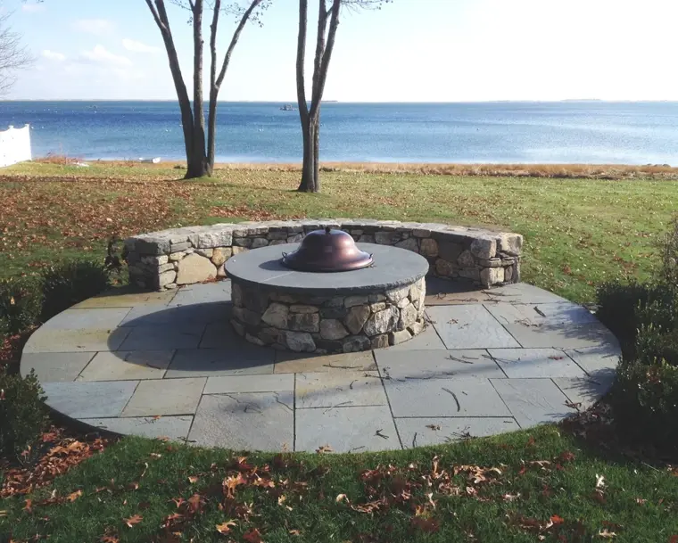 Bluestone fire pit patio with a fieldstone seat wall by the water