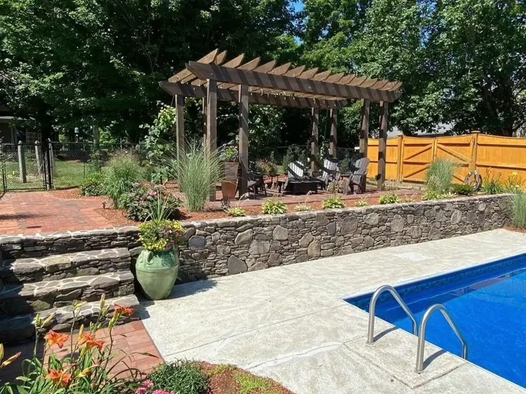 Pool patio with stone retaining wall and steps